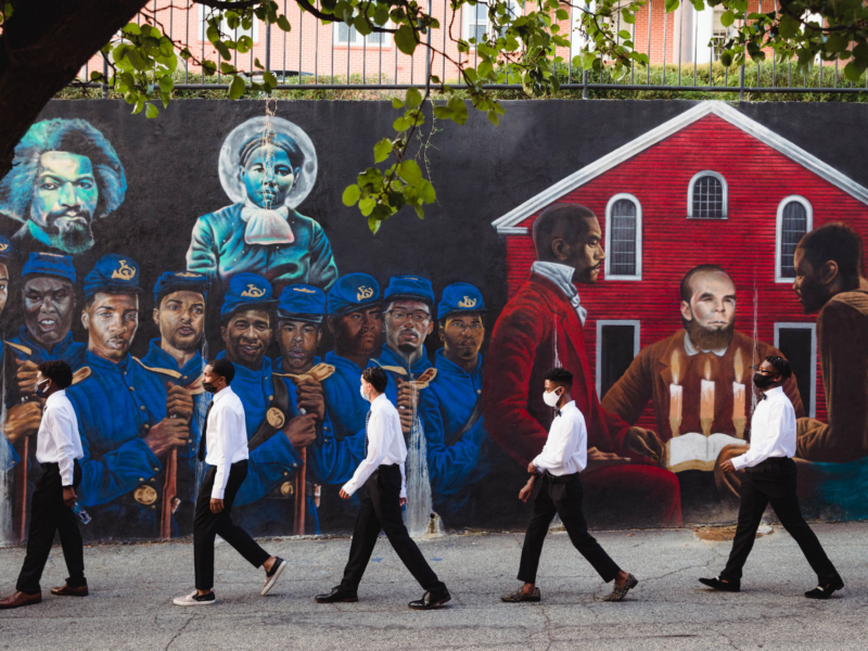 Incoming students at Morehouse, a Historically Black college in Atlanta, Georgia, walk past a mural depicting Black history on their way to New Student Orientation 2021. Credit: Photo via Morehouse College on Facebook.