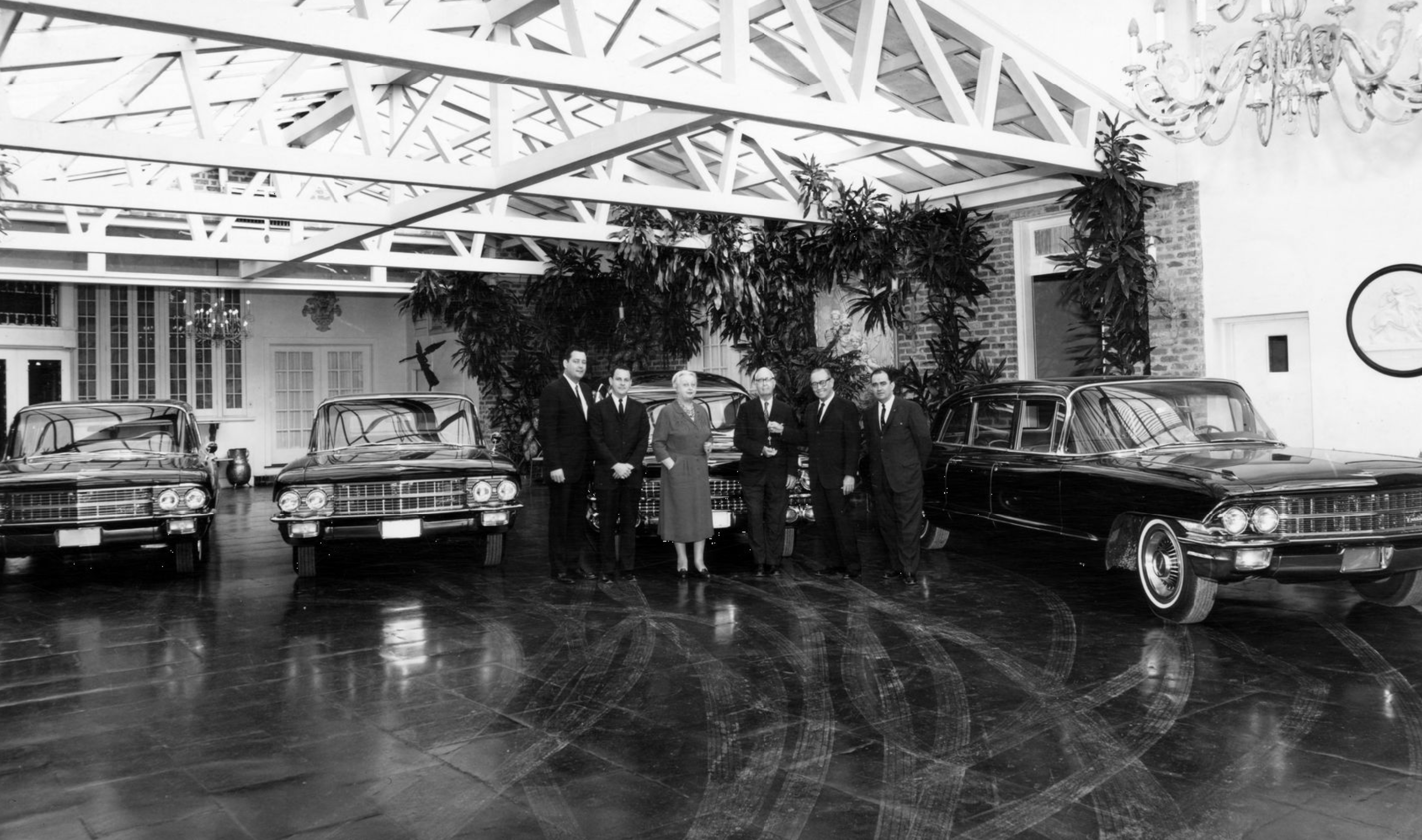 View of four new Cadillacs in a foyer with a group of six people posing in front of them at the Bultman Funeral Home in 1961. Archive photo via the Louisiana Digital Library, Charles L. Franck and Franck-Bertacci Photograph Collections.