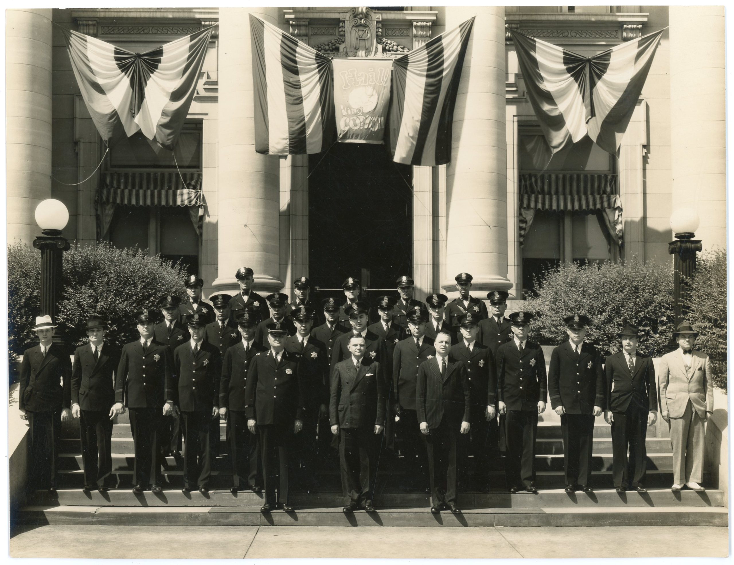 Group of police officers outside the Memphis Police Station at 128 Adams Avenue, Memphis, Tennessee, undated (1930s). The photograph was taken during Cotton Carnival. Commissioner of Public Safety Clifford Davis is in the middle of the front row. Photographer: Tuttle, Bureau of Identification, Memphis Police. How Black Memphis music resists police with the Blues.