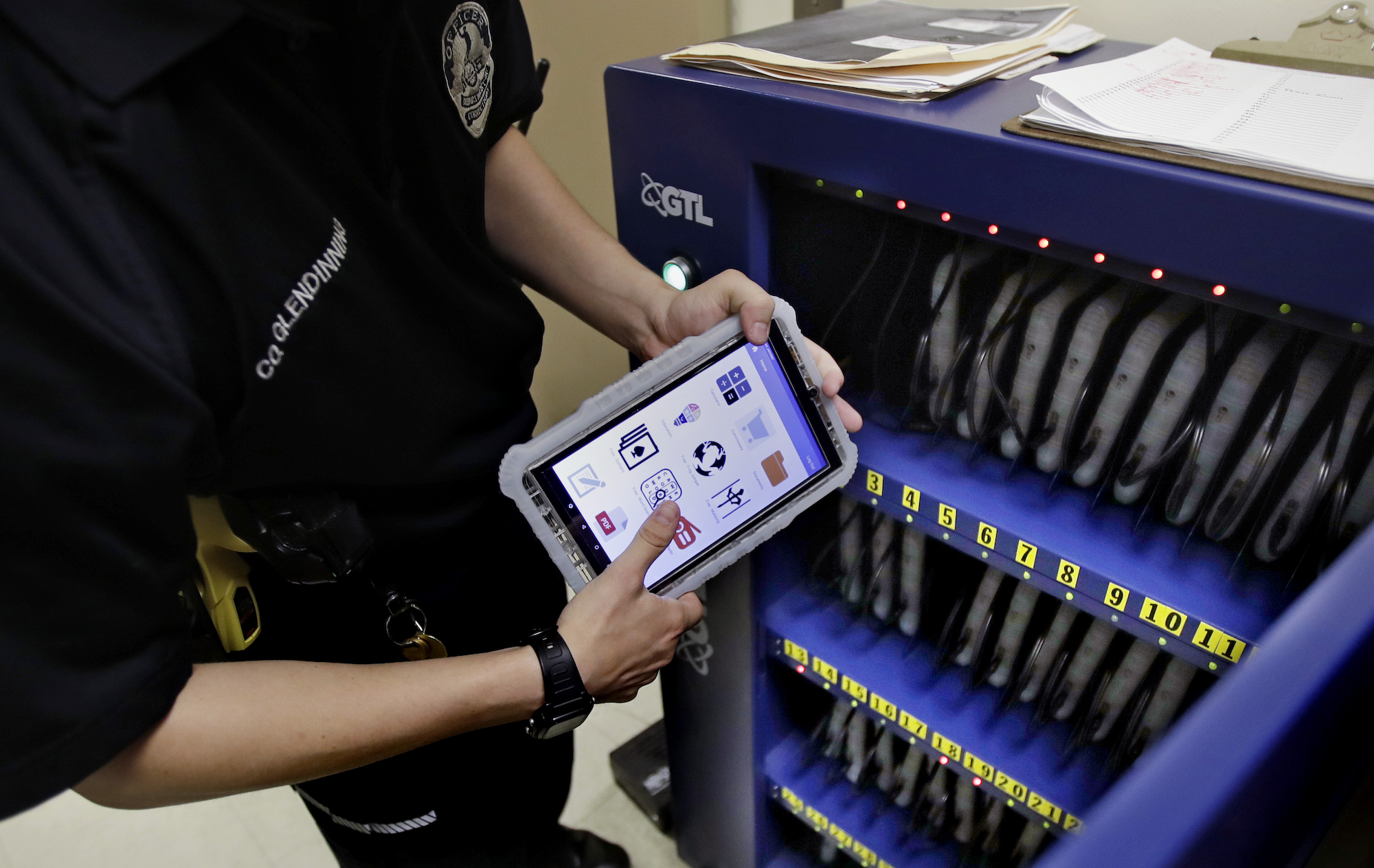 New Hampshire Department of Corrections Officer Glen Dinning puts a tablet back into a charging cabinet at the Corrections Transitional Work Center, a low risk security section at the New Hampshire State Prison for Men, in Concord, N.H. in 2018. (AP Photo/Charles Krupa) The hidden cost of 'free' tablets in prison