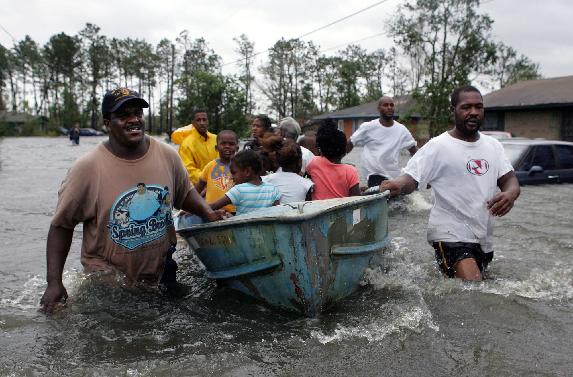 Rescuers use an old row boat to evacuate children from their flooded homes in Gulfport, Mississippi, after Hurricane Katrina struck the Gulf Coast on Monday, August 29, 2005. (AP Photo/John Bazemore) Over 18 years after Hurricane Katrina, survivors' ongoing battles with trauma, mental health, and PTSD reveal the long shadow of environmental racism on Black mental health.