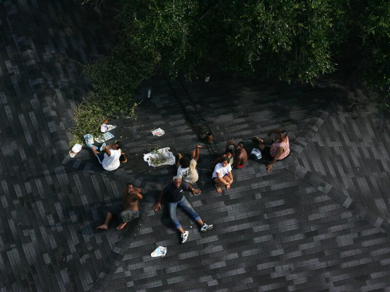 Residents seek higher ground on the roof of a home as floodwaters from Hurricane Katrina cover the streets on Tuesday, August 30, 2005 in New Orleans. (AP Photo/ Vincent Laforet, Pool) What we can learn from Hurricane Katrina preparedness failures and the deep inequities in federal disaster response efforts they exposed.