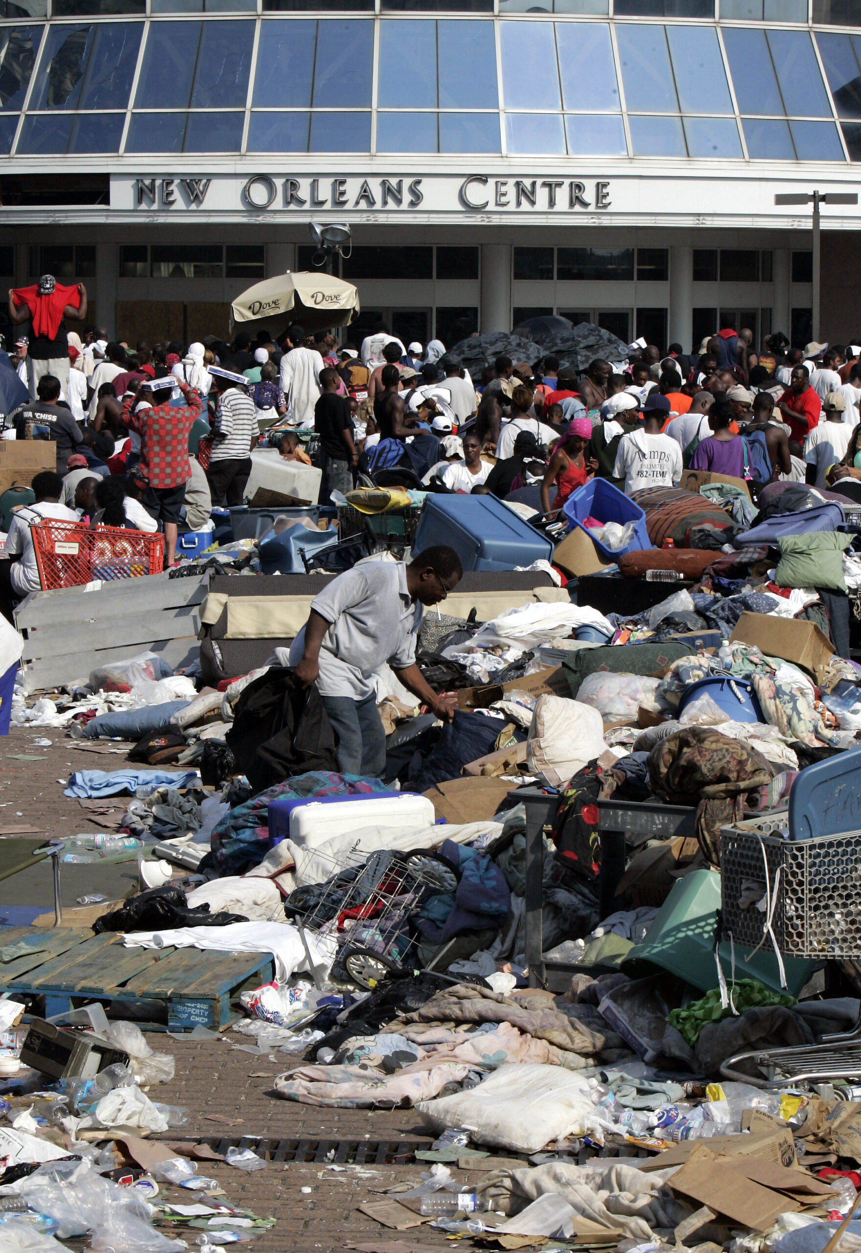 A flood victim picks through the trash that remains outside the New Orleans Center next to the Louisiana Superdome on Friday, September 2, 2005. (AP Photo/Bill Haber)
Over 18 years after Hurricane Katrina, survivors' ongoing battles with trauma, mental health, and PTSD reveal the long shadow of environmental racism on Black mental health.