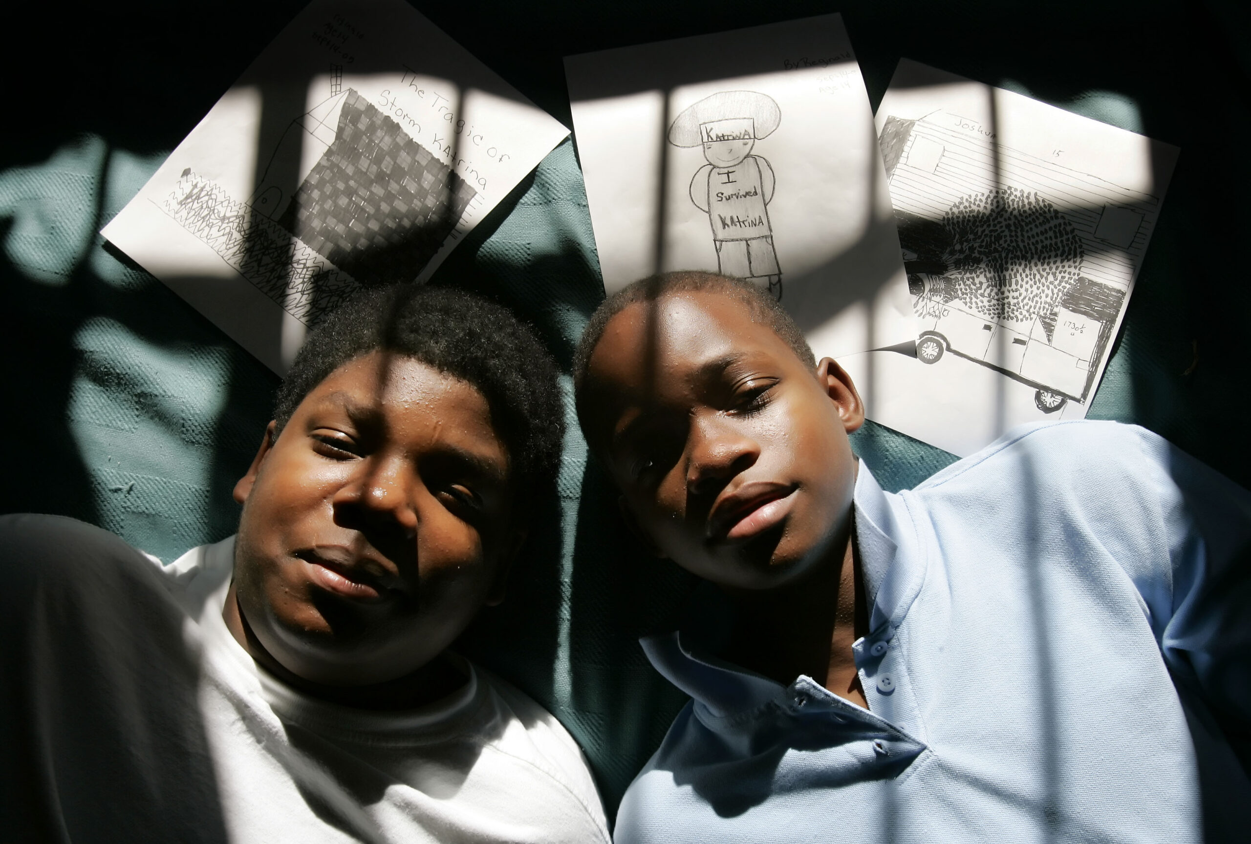 Hurricane Katrina evacuees Joshua Hilton, right and his brother Reginald Otkins shown on Thursday, December 15, 2005, in Houston with some of their drawings made through art therapy with the Katrina's Kids Project. The exhibit was culled from more than 600 drawings that were done by children over a 14-day period in September at the Astrodome and Reliant Center shelters in Houston. (AP Photo/David J. Phillip)
Over 18 years after Hurricane Katrina, survivors' ongoing battles with trauma, mental health, and PTSD reveal the long shadow of environmental racism on Black mental health.